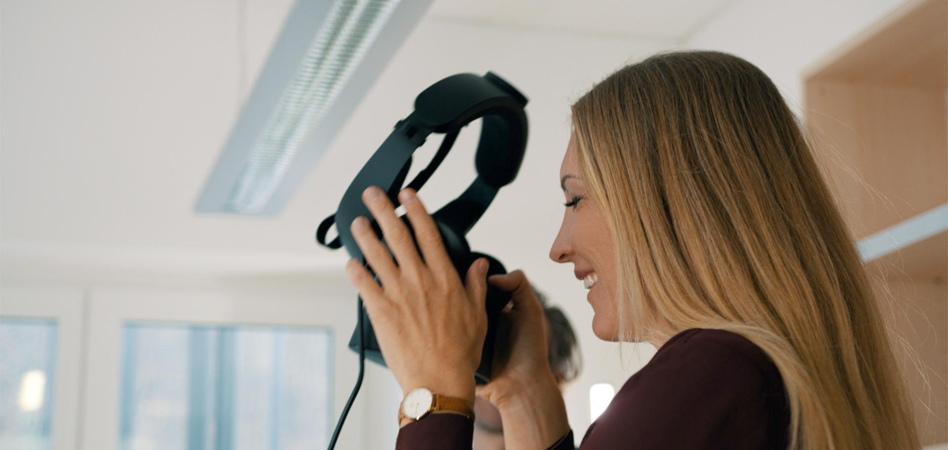 Foto einer Frau, die gerade eine VR-Brille aufsetzt